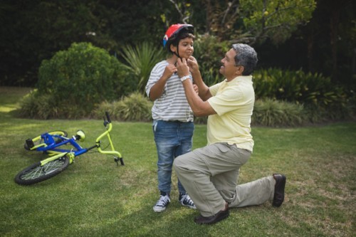 dad buckling his son's bike helmet